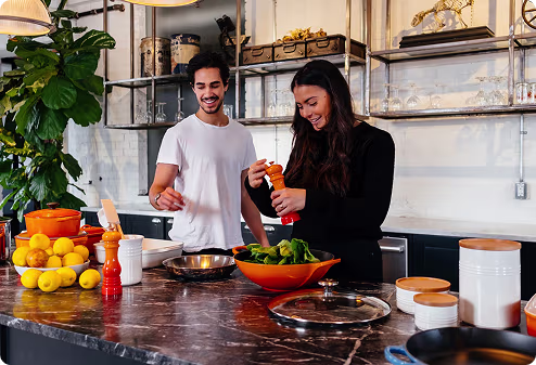 Two people preparing food together in a kitchen